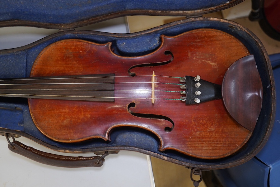 A late 19th century violin, bears fake Stradivarius label, cased, back measures 36cm. Condition - fair